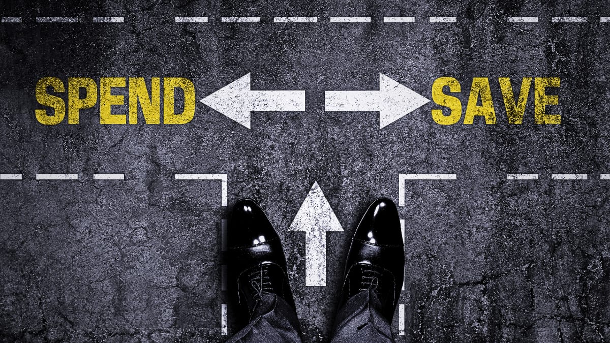 A person standing on the crossroad between spendings and savings, representing financial decision making